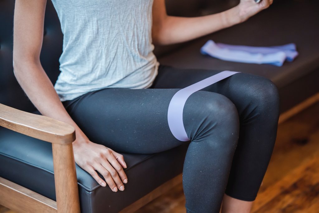 woman sitting with resistance band exercise.