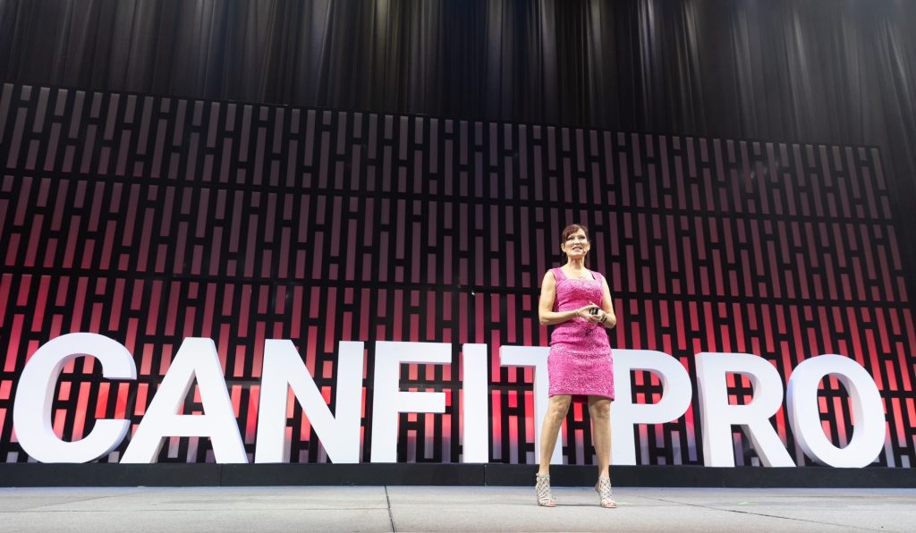Mo Hagan presenting at the canfitpro Women Who Influence conference stage.
